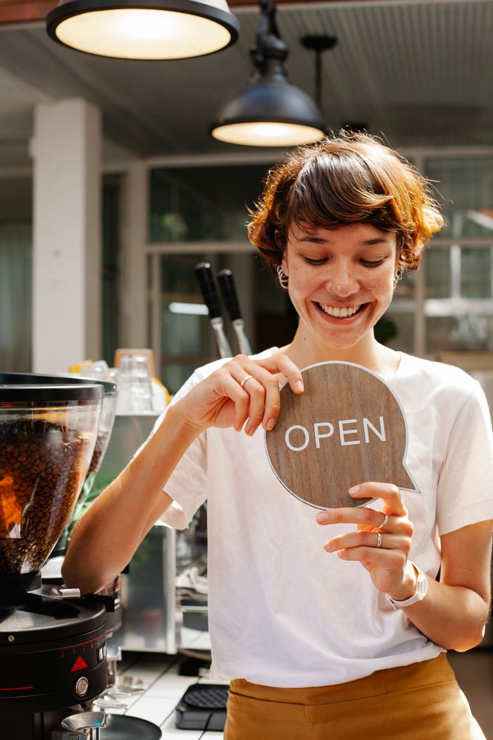 A cafe owner flips her open sign