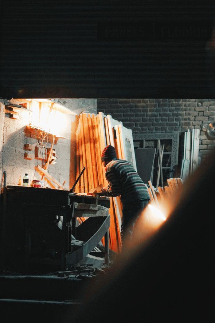 A woodworker planing a board in a workshop